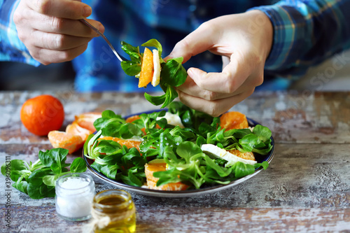 Selective focus. Male hands with a plate of salad at the table. Healthly food. Healthy salad.