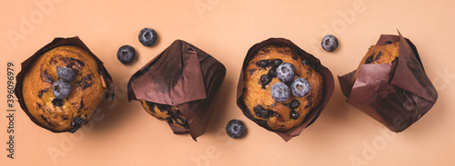 Homemade Blueberry Muffins with Berries on Light Brown Background Top View Long