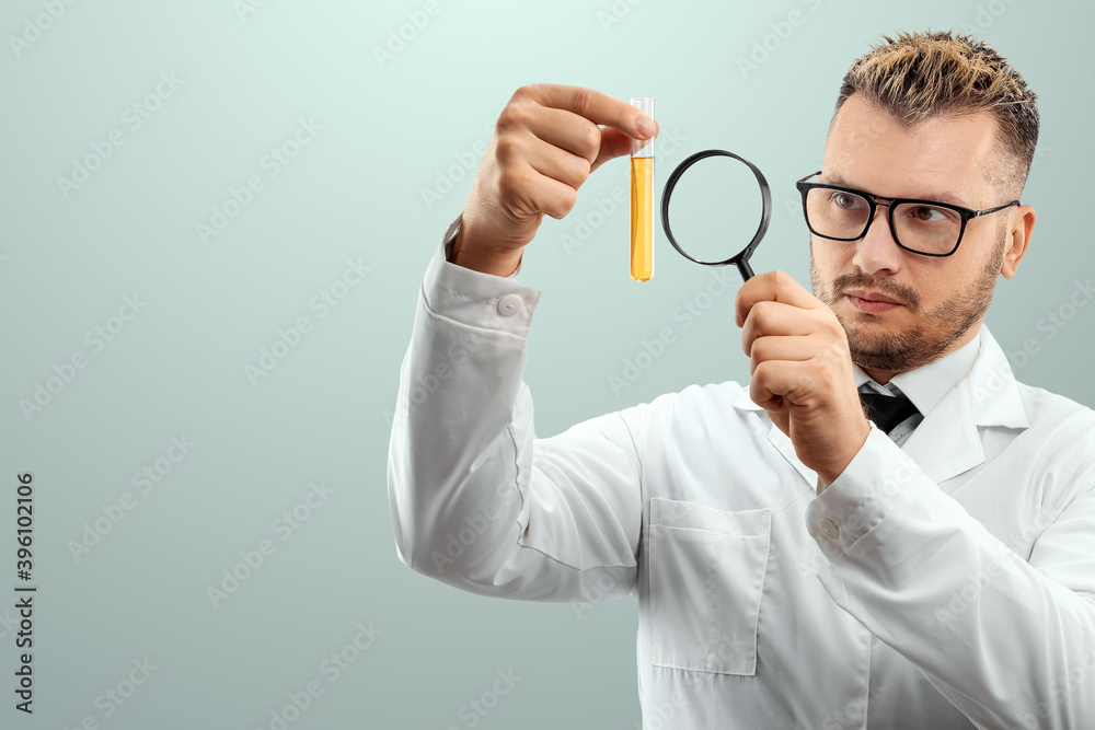 The doctor looks at a test tube with liquid through a magnifying glass, loupe. Scientific research concept, vaccine invention, COVID-19. copy space. The doctor looks at a test tube with liquid through a magnifying glass, loupe. Scientific research concept, vaccine invention, COVID-19. copy space.