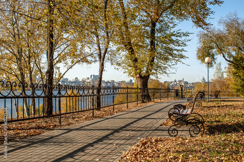  Embankment with a bench and a lantern on a sunny autumn day
