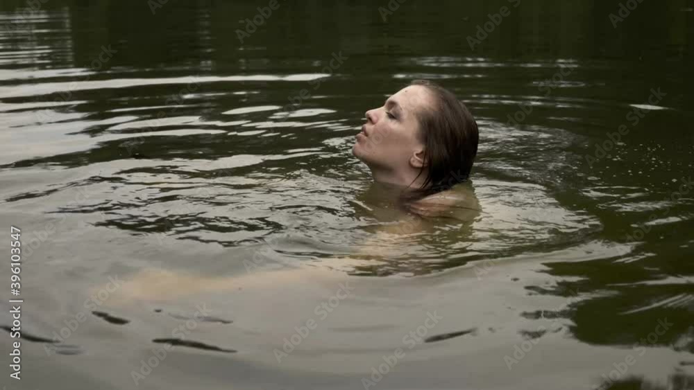 Close-up portrait of a cute woman balancing on the water surface of a deep forest lake Close-up portrait of a cute woman balancing on the water surface of a deep forest lake