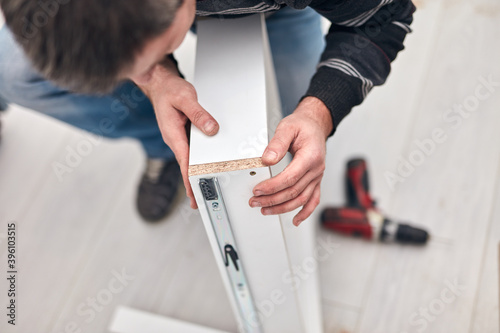 Handyman worker assembling furniture and fixing it.