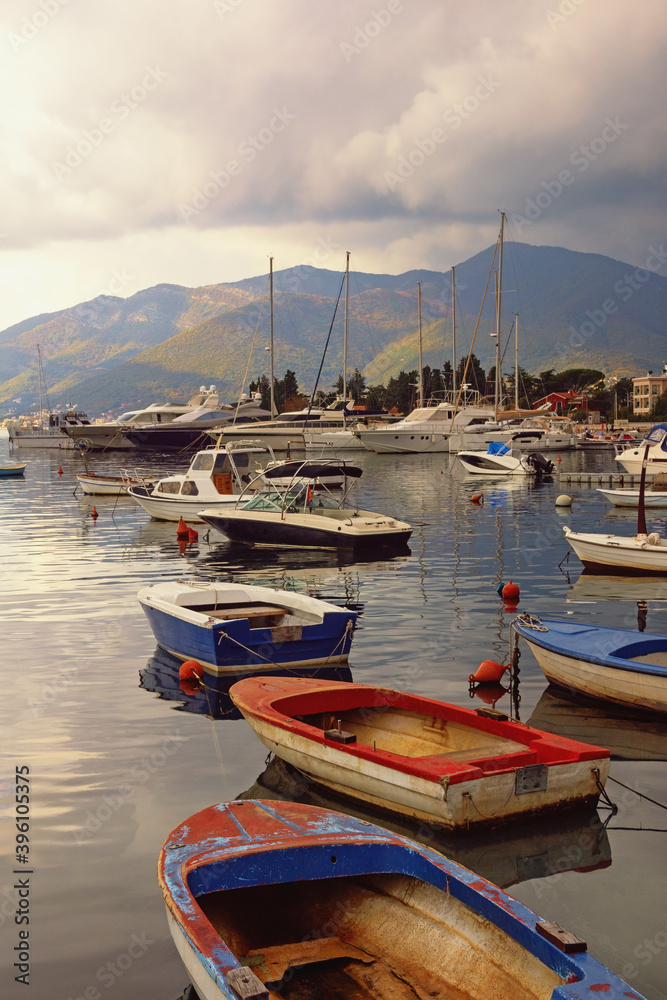 Cloudy autumn day. Mediterranean landscape with fishing boats on water. Montenegro, view of Kotor Bay near Tivat city