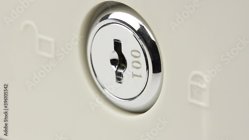 man turns the key in the lock several times, opens and closes lock, close-up view on larva of lock of safe or cash drawer