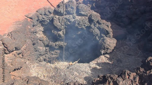 Smoke coming out of volcanic crater at Timanfaya National Park. Straw burning demonstration at Lanzarote tourist attraction. Geothermal energy, earth heat concepts