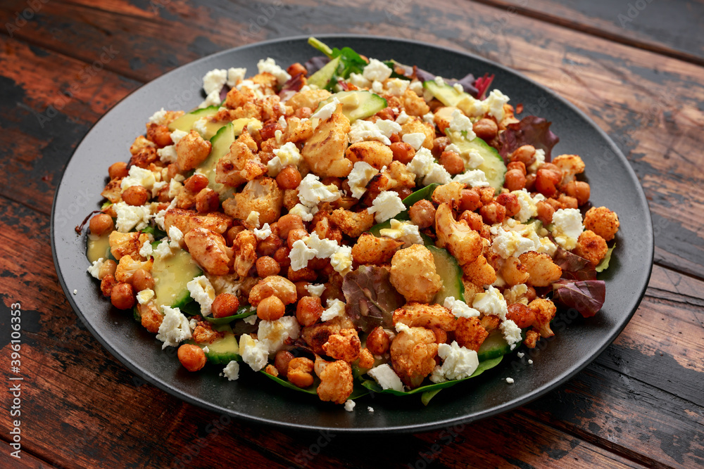Roasted Cauliflower salad with chickpea, cucumber, greens and feta cheese. healthy food Roasted Cauliflower salad with chickpea, cucumber, greens and feta cheese. healthy food