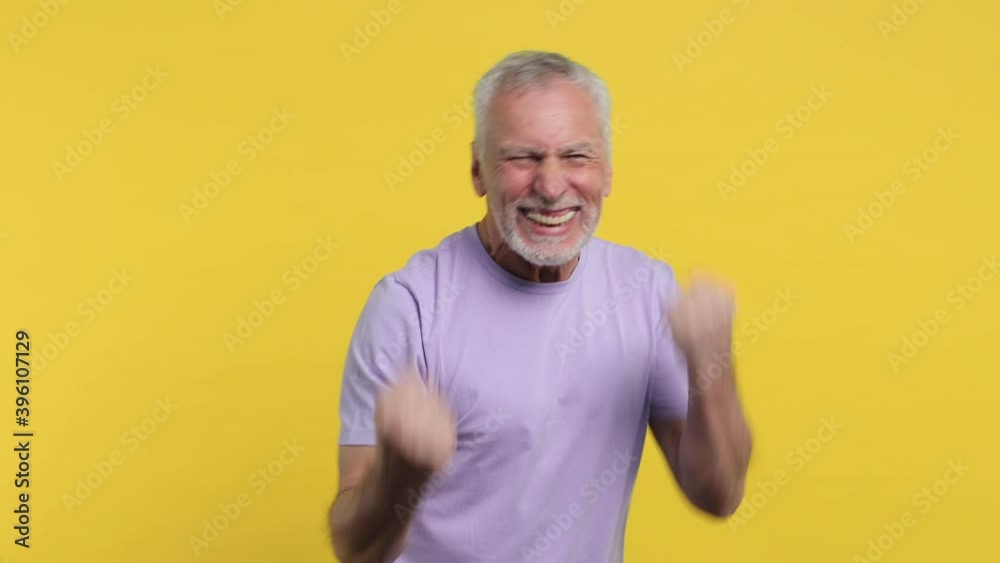 Side view of happy elderly gray-haired mustache bearded man in violet t-shirt isolated on yellow background studio. People lifestyle concept. Turn around camera doing winner gesture put hands on head Side view of happy elderly gray-haired mustache bearded man in violet t-shirt isolated on yellow background studio. People lifestyle concept. Turn around camera doing winner gesture put hands on head