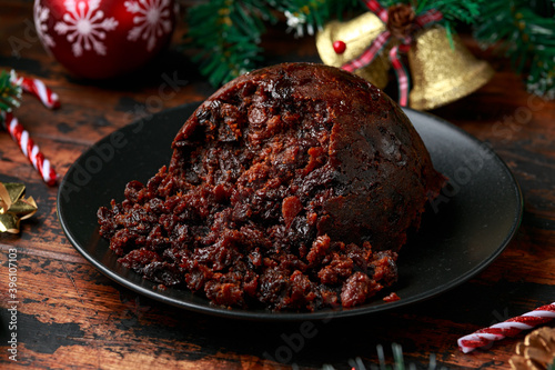 Tablou pe pânză Christmas pudding with decoration, gifts, green tree branch on wooden rustic tab
