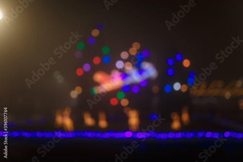 Unfocused night shot of Christmas garland lights bokeh in the city. Happy New Year, Merry Christmas, winter holidays concept.