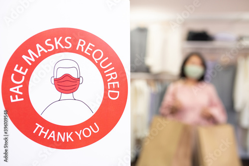 Part of wall in clothing department with announcement about masks requirement