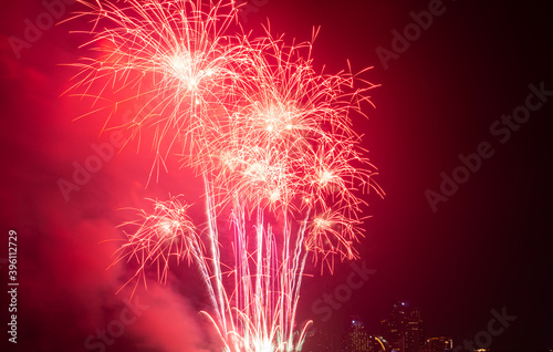 Firework festival with beach foreground and city background at Pattaya beach  Thailand. Colorful firework in celebration festival background
