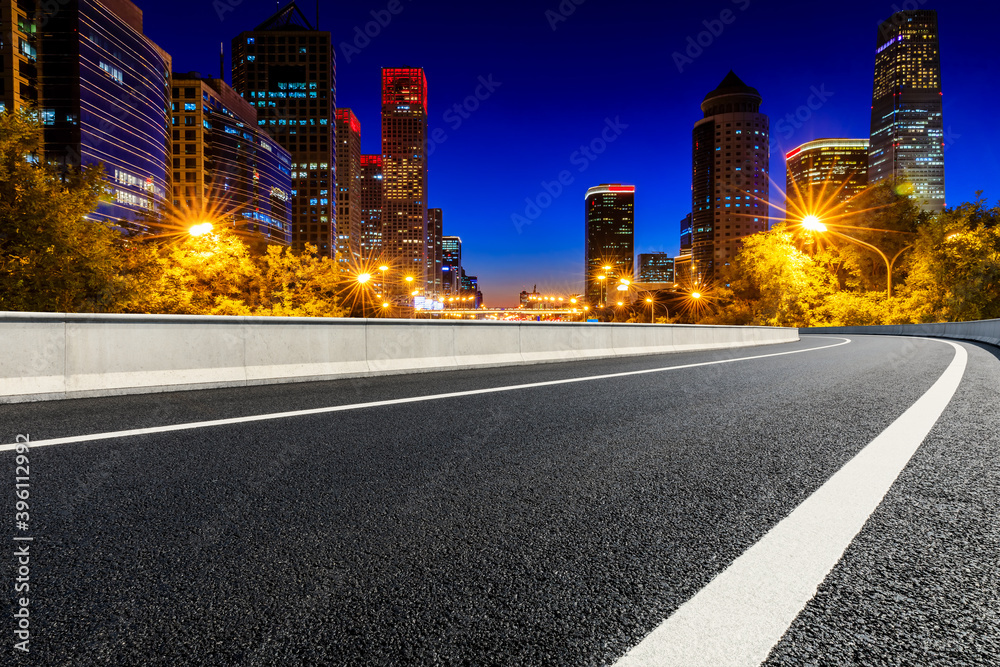 Empty asphalt road and modern cityscape in Beijing at night,China.