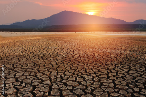 Cracked soil arid with sunset sky background, global warming and climate change concept