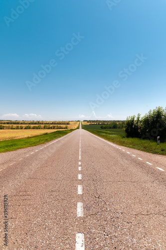 Country asphalt road through agricultural fields on a sunny day. Logistics and transport background © yanik88
