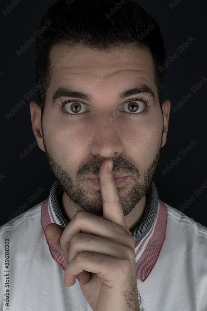 Mann hält seinen Finger vor den Mund und bittet um Ruhe Mann hält seinen Finger vor den Mund und bittet um Ruhe