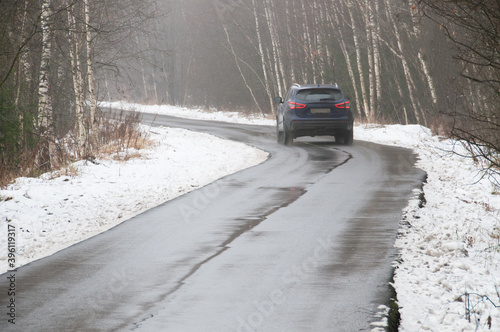 Car driving on slippery wet road, winter