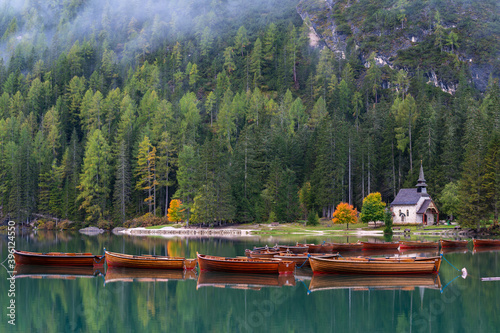 Little chapel at Lake Braies (Pragser Wildsee, Lago di Braies) with boats in foreground. Region of Trentino Alto Adige, Dolomites, Italy