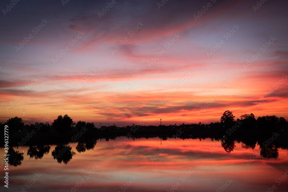 Sunset over lake with red orange sky.