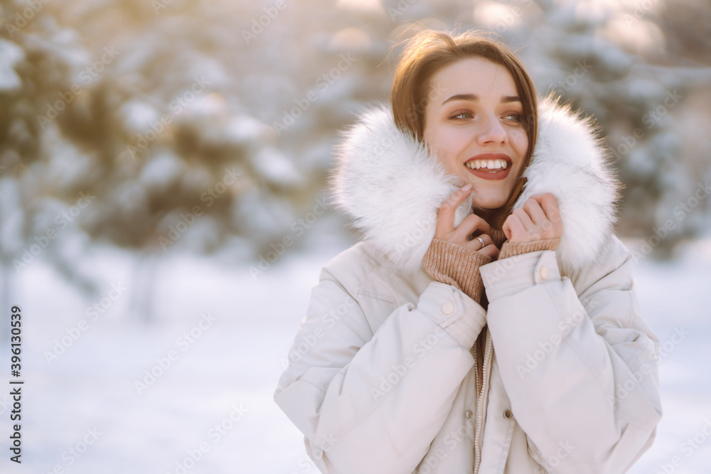 Beautiful woman in winter clothes posing in a snowy park. Young lady walking in a sunny winter day in the forest. Winter fashion, holidays, rest, travel concept. Beautiful woman in winter clothes posing in a snowy park. Young lady walking in a sunny winter day in the forest. Winter fashion, holidays, rest, travel concept.