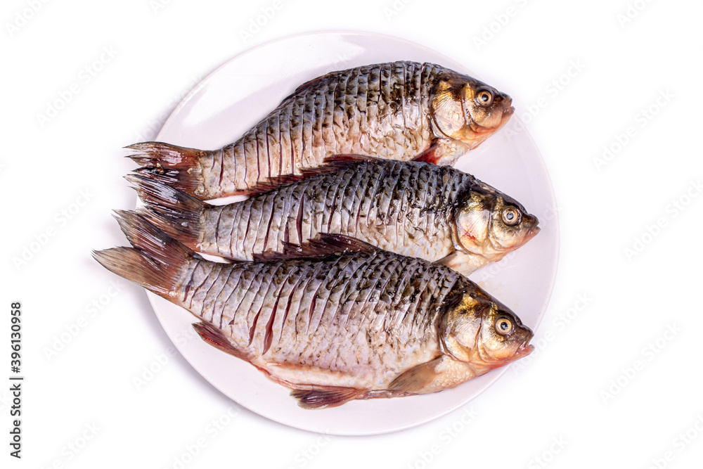 Fresh crucian fish on a plate, prepared for frying. Freshwater fish. Fresh crucian fish on a plate, prepared for frying. Freshwater fish.