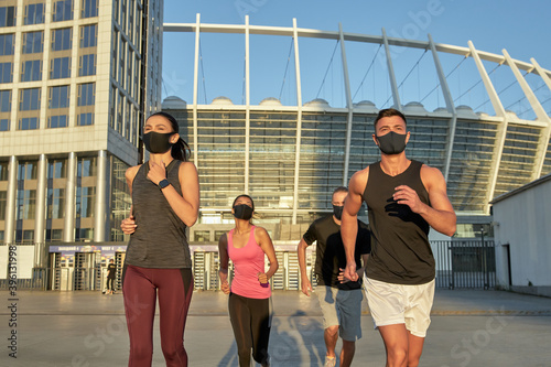 Fototapeta Naklejka Na Ścianę i Meble -  Young multi racial runners in protective masks training