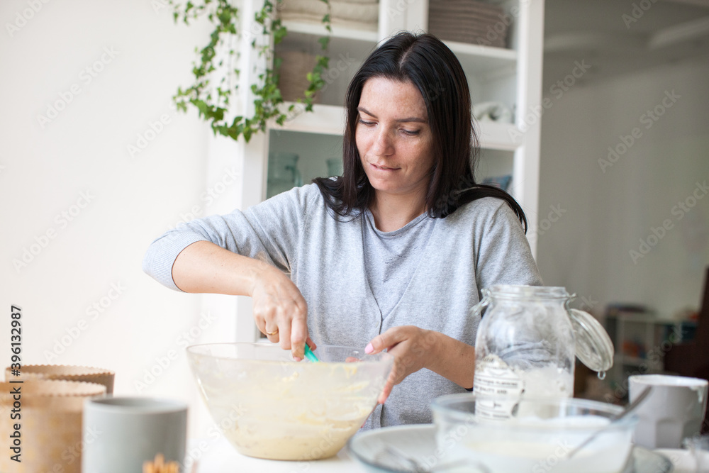 Young woman in white clothes kneading a pie of white flour on a white background. Soft focus Young woman in white clothes kneading a pie of white flour on a white background. Soft focus