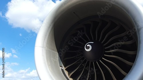 Jet turbine engine of aircraft rotating by wind with clouds and blue sky background.Aviation industry affected by coronavirus pandemic aircraft had to stop all flight plan.