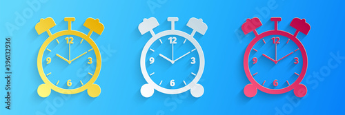Paper cut Alarm clock icon isolated on blue background. Wake up, get up concept. Time sign. Paper art style. Vector.