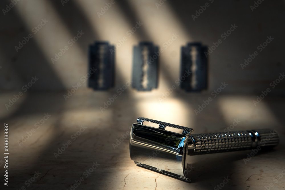 Reusable steel double edged eco-friendly safety razor on minimalist background with shadows. Zero waste sustainable plastic free lifestyle Reusable steel double edged eco-friendly safety razor on minimalist background with shadows. Zero waste sustainable plastic free lifestyle