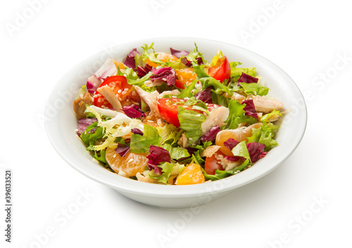 Salad with chicken, tangerines and vegetables in a white bowl isolated on white background. Close up.