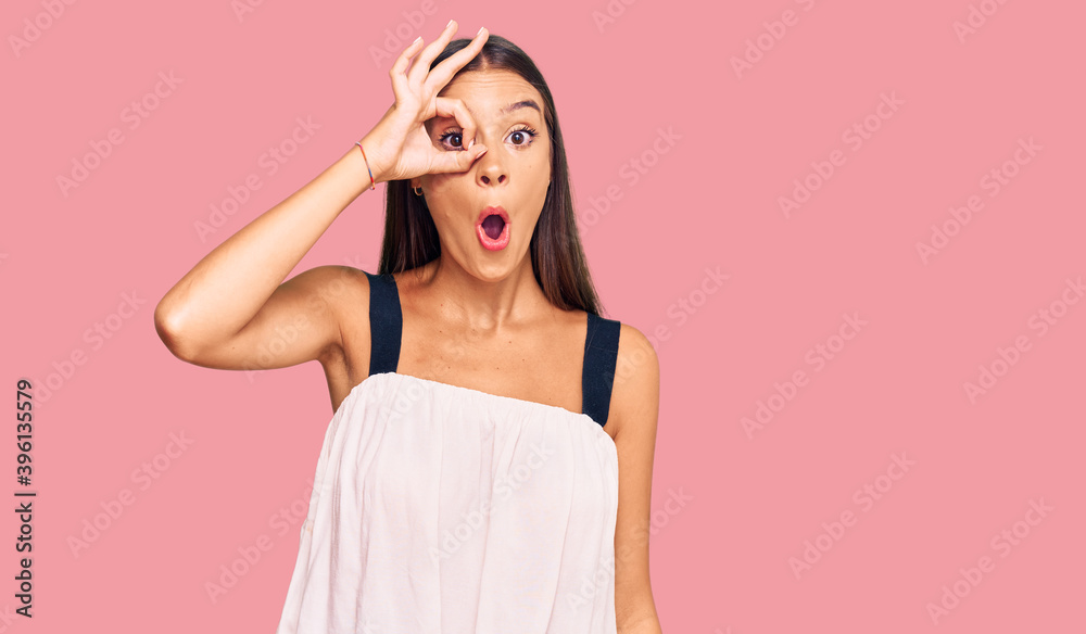 Young hispanic woman wearing casual clothes doing ok gesture shocked with surprised face, eye looking through fingers. unbelieving expression. Young hispanic woman wearing casual clothes doing ok gesture shocked with surprised face, eye looking through fingers. unbelieving expression.
