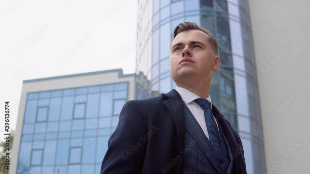 Portrait of a elegant businessman in blue jacket and coat near office center. A man waiting for business meeting Portrait of a elegant businessman in blue jacket and coat near office center. A man waiting for business meeting