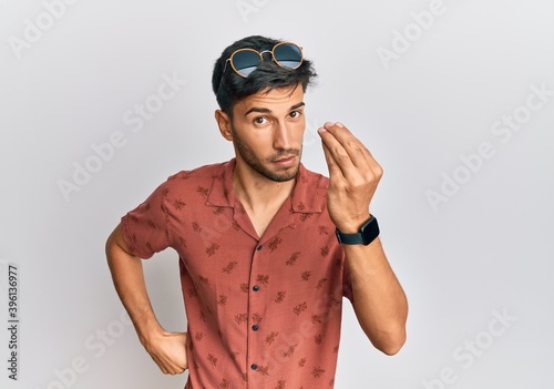 Young handsome man wearing casual summer clothes doing italian gesture with hand and fingers confident expression