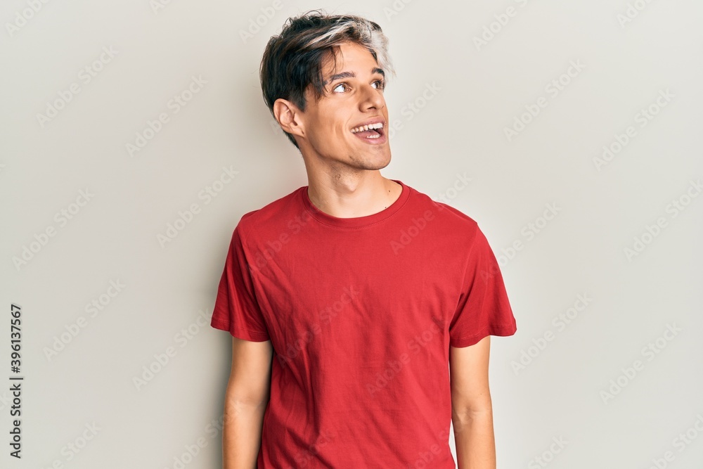Young hispanic man wearing casual clothes looking away to side with smile on face, natural expression. laughing confident. Young hispanic man wearing casual clothes looking away to side with smile on face, natural expression. laughing confident.
