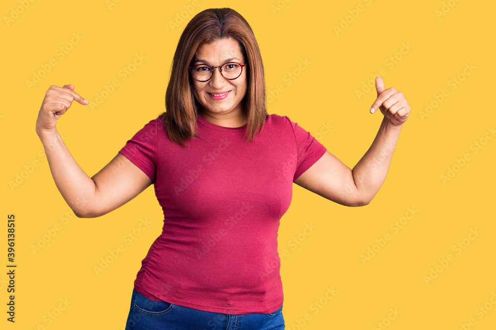 Middle age latin woman wearing casual clothes and glasses looking confident with smile on face, pointing oneself with fingers proud and happy. Middle age latin woman wearing casual clothes and glasses looking confident with smile on face, pointing oneself with fingers proud and happy.