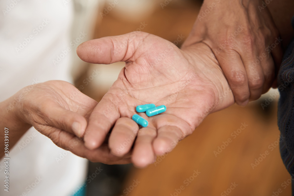 Blue medical capsules in male hand. Close up view of male hand holding pills in the palm. People, medicine and healthcare concept. Blue medical capsules in male hand. Close up view of male hand holding pills in the palm. People, medicine and healthcare concept.