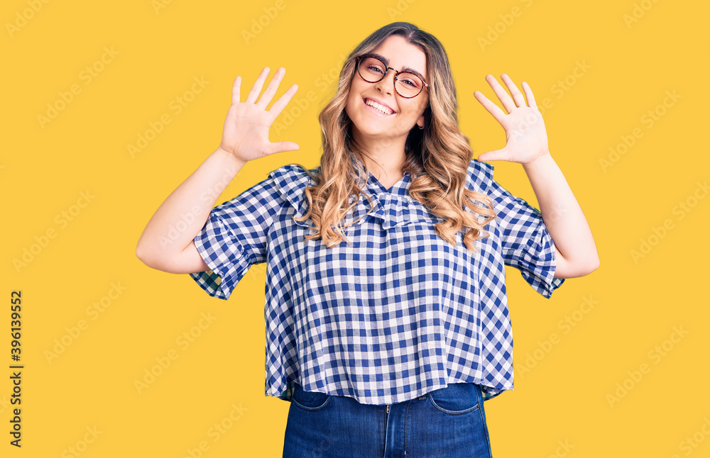 Young caucasian woman wearing casual clothes showing and pointing up with fingers number ten while smiling confident and happy. Young caucasian woman wearing casual clothes showing and pointing up with fingers number ten while smiling confident and happy.