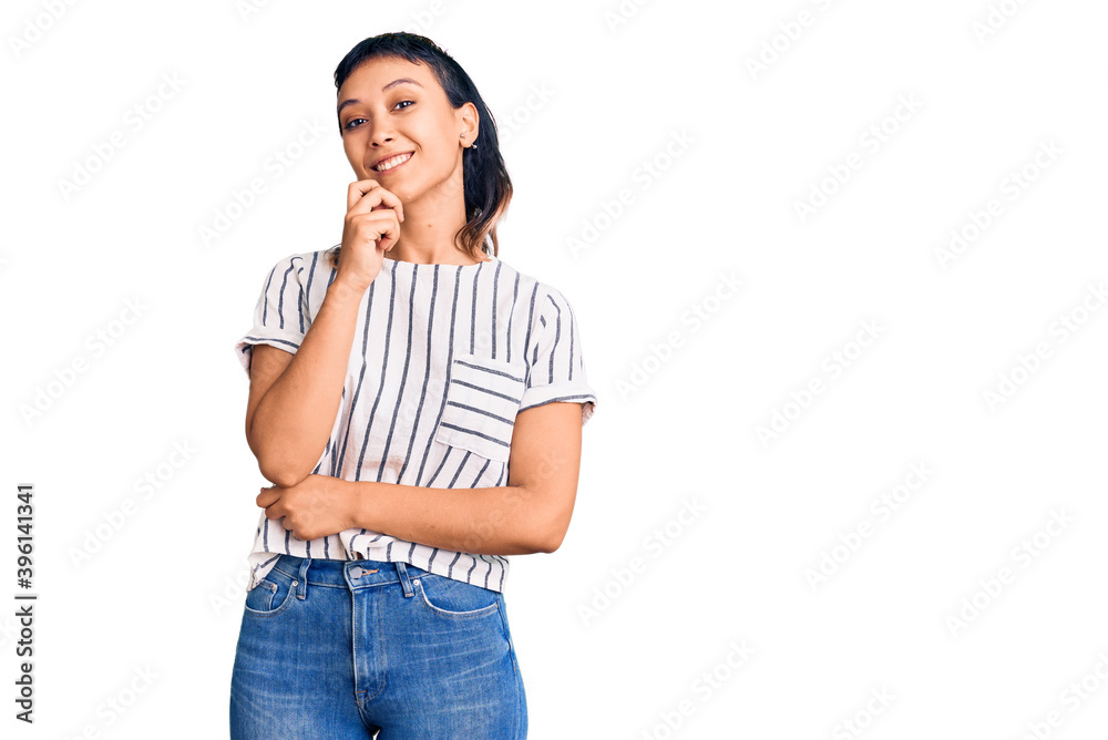 Young woman wearing casual clothes looking confident at the camera smiling with crossed arms and hand raised on chin. thinking positive. Young woman wearing casual clothes looking confident at the camera smiling with crossed arms and hand raised on chin. thinking positive.