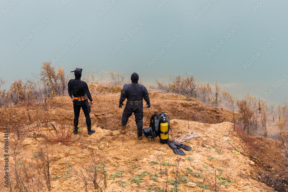 Obraz premium Lifeguard in a wetsuit to work underwater. Search at the bottom of the pond.