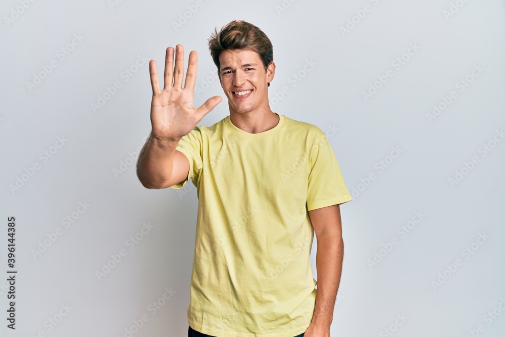 Handsome caucasian man wearing casual clothes showing and pointing up with fingers number five while smiling confident and happy. Handsome caucasian man wearing casual clothes showing and pointing up with fingers number five while smiling confident and happy.
