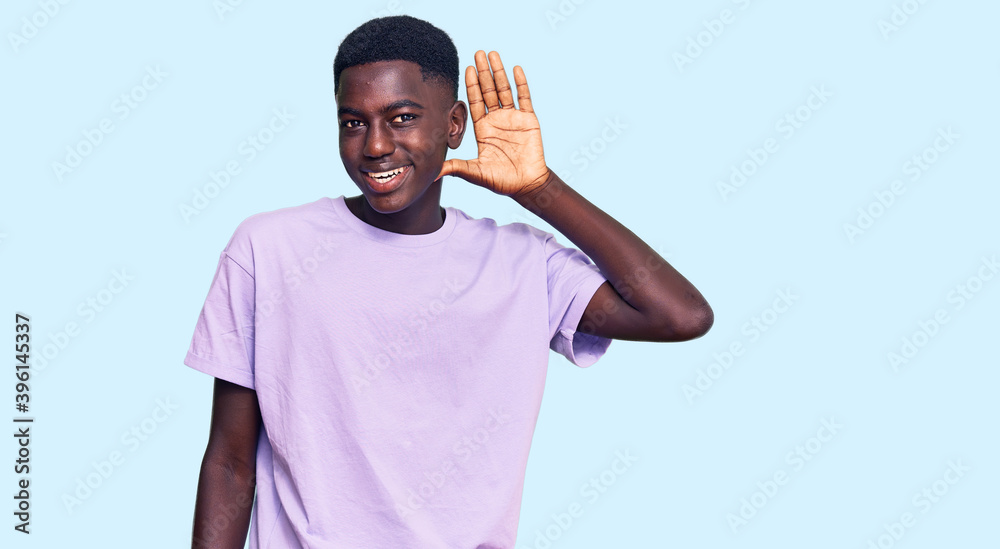 Young african american man wearing casual clothes smiling with hand over ear listening an hearing to rumor or gossip. deafness concept. Young african american man wearing casual clothes smiling with hand over ear listening an hearing to rumor or gossip. deafness concept.