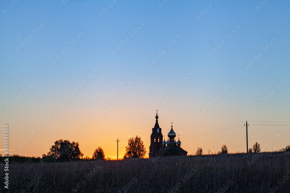 Naklejka premium Church at sunset. On a yellow background, the black silhouette of the spiers of the Cathedral