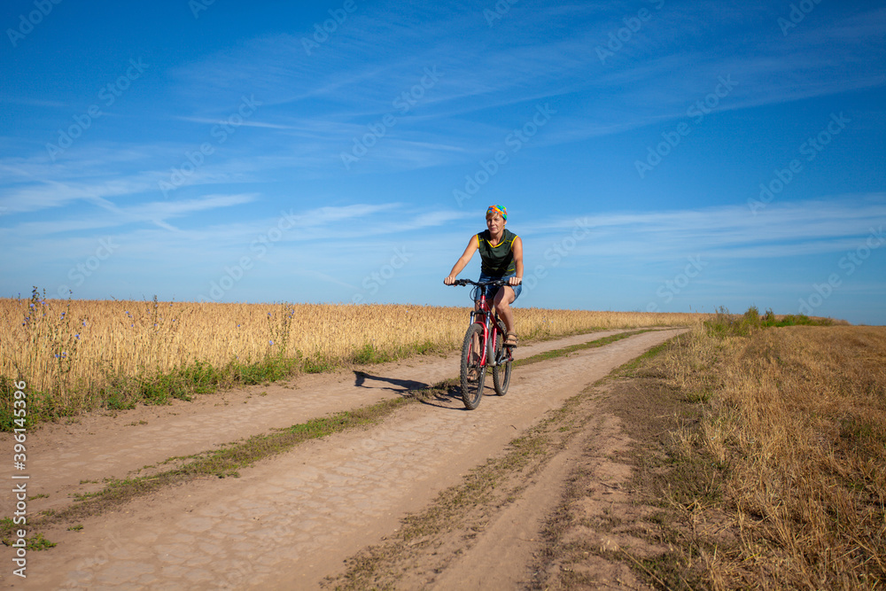 Henchie rides a bicycle on a country road