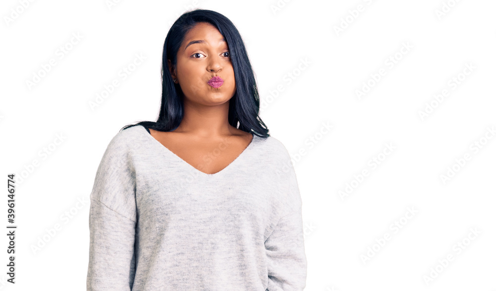 Hispanic woman with long hair wearing casual clothes puffing cheeks with funny face. mouth inflated with air, crazy expression. Hispanic woman with long hair wearing casual clothes puffing cheeks with funny face. mouth inflated with air, crazy expression.