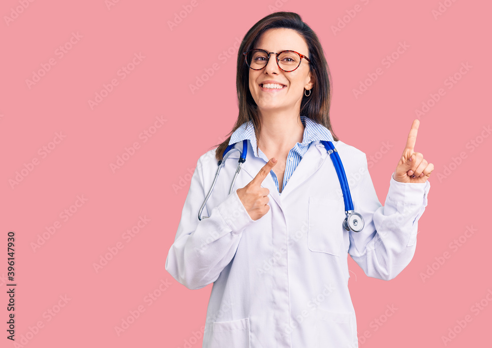 Young beautiful woman wearing doctor stethoscope and glasses smiling and looking at the camera pointing with two hands and fingers to the side. Young beautiful woman wearing doctor stethoscope and glasses smiling and looking at the camera pointing with two hands and fingers to the side.