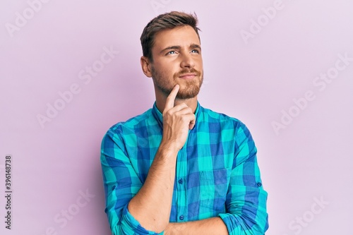 Handsome caucasian man wearing casual clothes serious face thinking about question with hand on chin, thoughtful about confusing idea