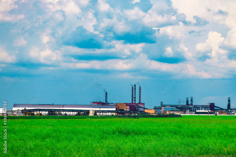 Fumes of a mining plant against the sky and green grass. Fumes of a mining plant against the sky and green grass.