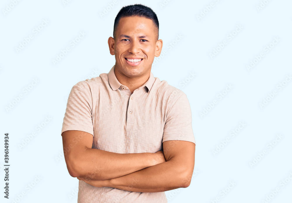 Young handsome latin man wearing casual clothes happy face smiling with crossed arms looking at the camera. positive person. Young handsome latin man wearing casual clothes happy face smiling with crossed arms looking at the camera. positive person.
