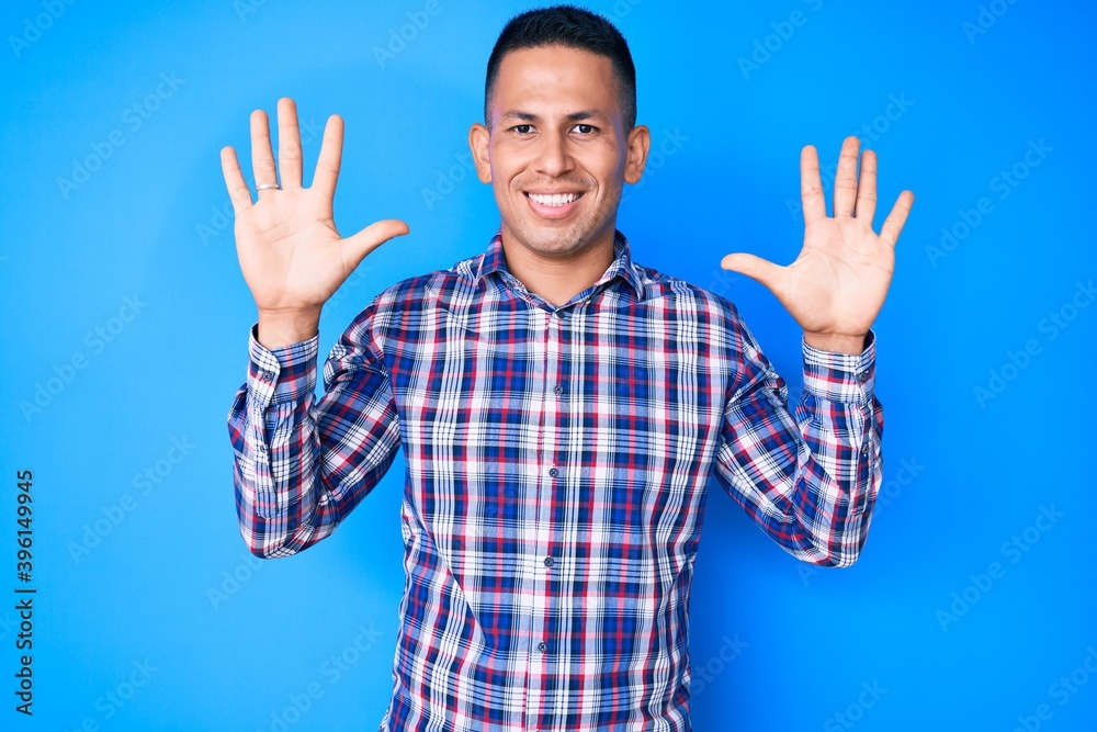 Young handsome latin man wearing casual clothes showing and pointing up with fingers number ten while smiling confident and happy. Young handsome latin man wearing casual clothes showing and pointing up with fingers number ten while smiling confident and happy.