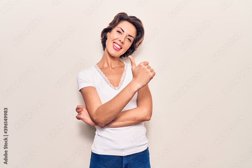 Young beautiful woman wearing casual clothes doing happy thumbs up gesture with hand. approving expression looking at the camera showing success. Young beautiful woman wearing casual clothes doing happy thumbs up gesture with hand. approving expression looking at the camera showing success.